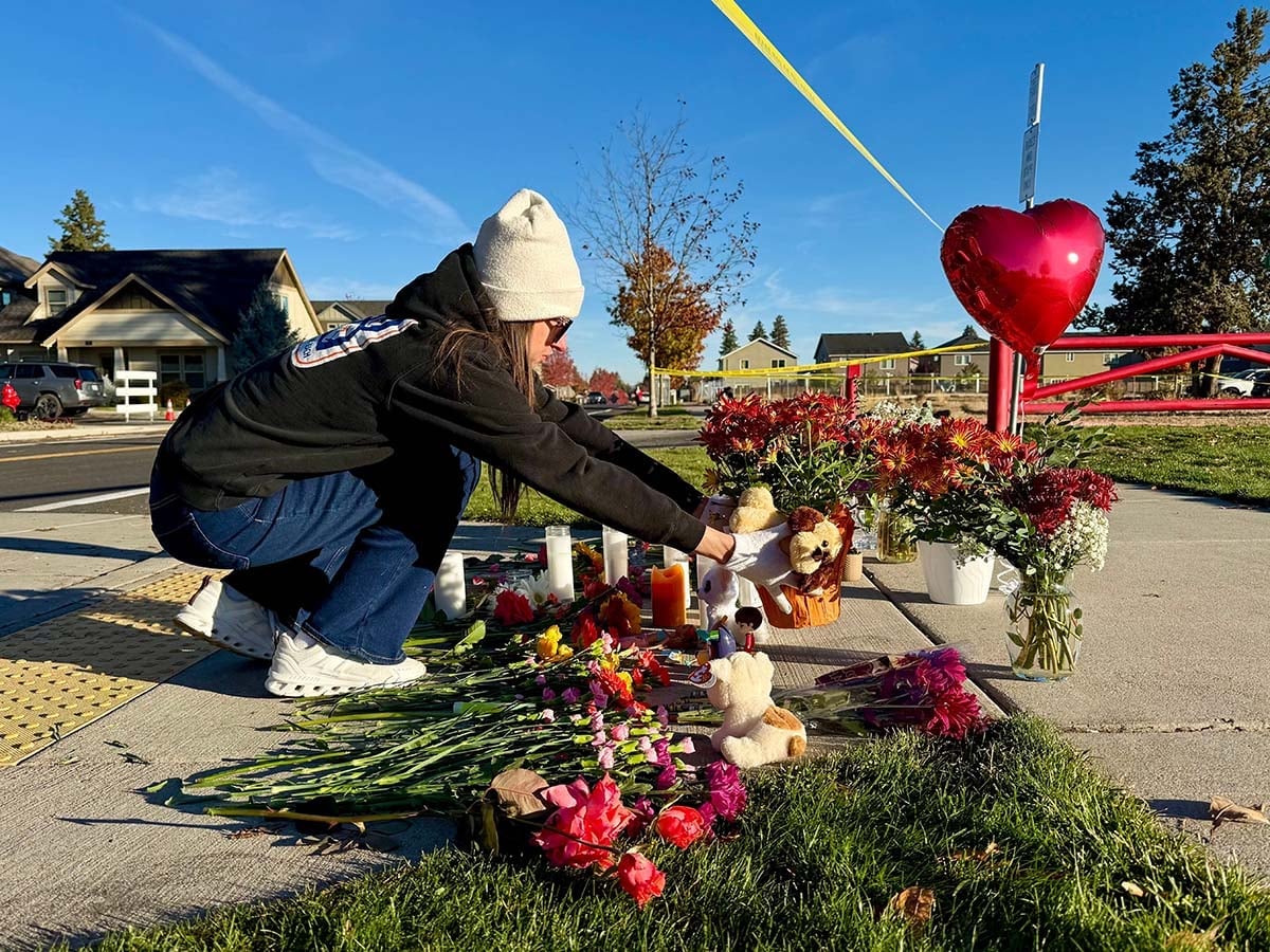 Flowers, candles, stuffed animals and a red heart balloon at the Silver Rail community memorial.